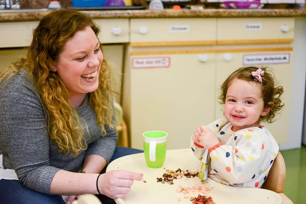 Care provider interacting with child at one of our employee owned child care centers in new york city